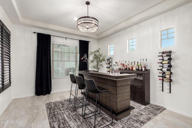 5212 S Seton Ct, Gilbert, AZ 85298 - indoor dry bar with a chandelier, a tray ceiling, baseboards, and decorative light fixtures