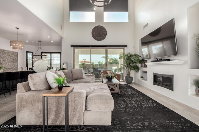 5212 S Seton Ct, Gilbert, AZ 85298 - living area with a glass covered fireplace, a towering ceiling, and recessed lighting