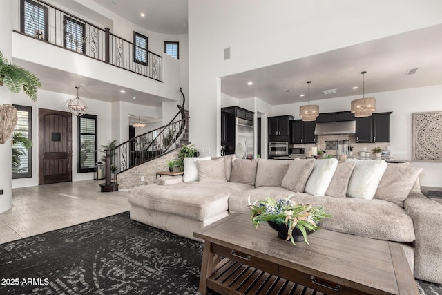 5212 S Seton Ct, Gilbert, AZ 85298 - living room with stairs, healthy amount of natural light, light wood-style flooring, a chandelier, and recessed lighting