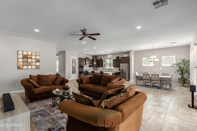 living room with recessed lighting, visible vents, baseboards, and ceiling fan with notable chandelier