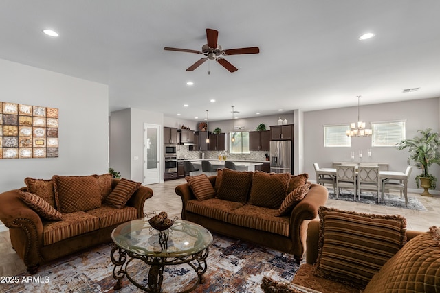 living area with a healthy amount of sunlight, recessed lighting, visible vents, and ceiling fan with notable chandelier