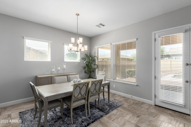 dining area featuring a notable chandelier, visible vents, and baseboards