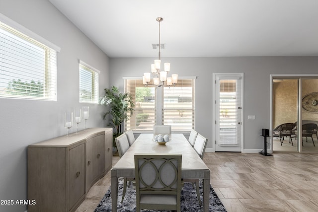 dining room with a chandelier, visible vents, and baseboards