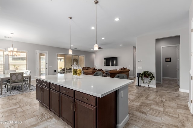 kitchen with recessed lighting, light countertops, decorative light fixtures, and dark brown cabinets