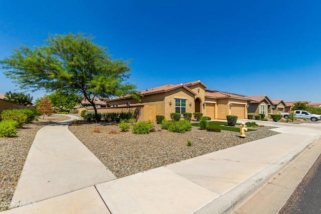 view of front of home featuring concrete driveway, a tiled roof, an attached garage, and stucco siding