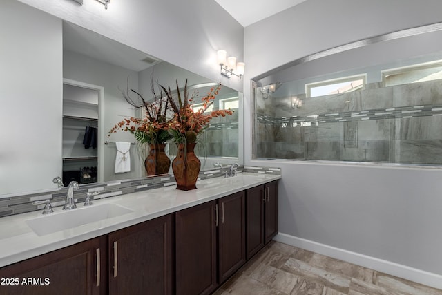 bathroom with double vanity, visible vents, walk in shower, and a sink