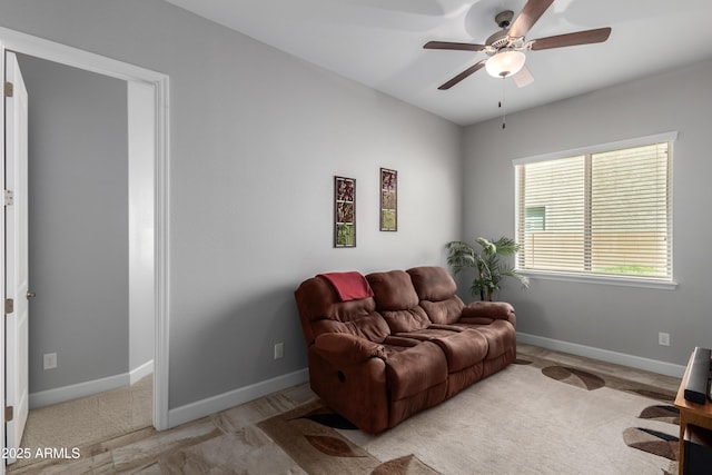 living room with a ceiling fan and baseboards