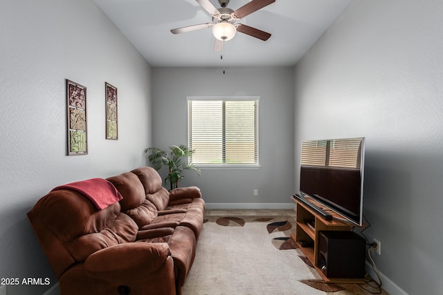 carpeted living room featuring ceiling fan and baseboards