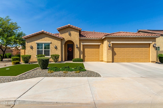 mediterranean / spanish-style home with an attached garage, driveway, a tiled roof, and stucco siding