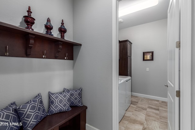 interior space featuring washing machine and dryer, cabinet space, and baseboards