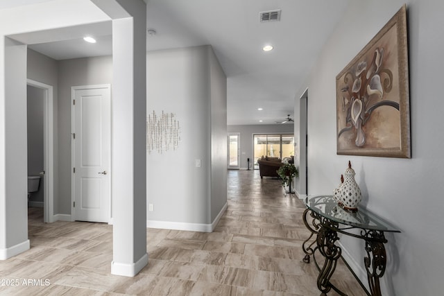 hallway with recessed lighting, visible vents, and baseboards