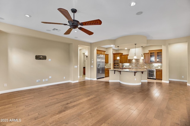 1620 E Sattoo Way, Queen Creek, AZ 85140 - unfurnished living room featuring beverage cooler, ceiling fan, recessed lighting, wood finished floors, and baseboards