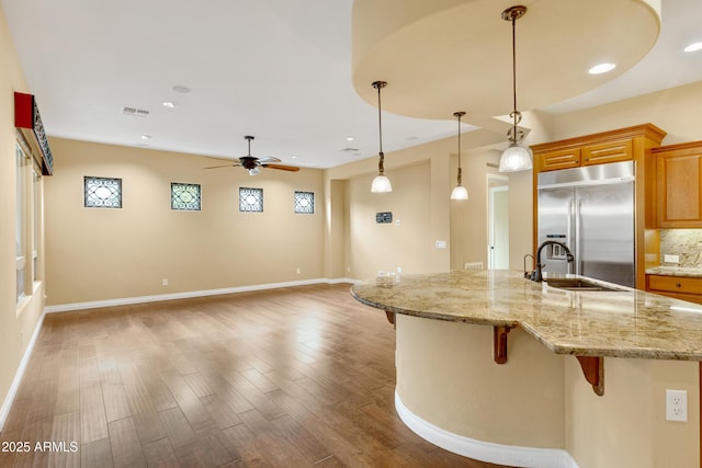 1620 E Sattoo Way, Queen Creek, AZ 85140 - kitchen featuring stainless steel built in fridge, a sink, a breakfast bar, ceiling fan, and wood finished floors