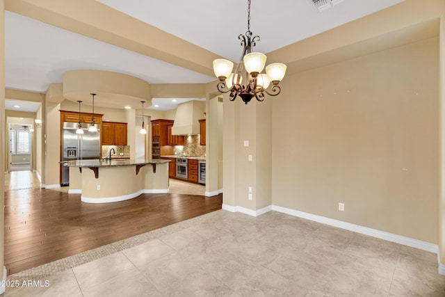 1620 E Sattoo Way, Queen Creek, AZ 85140 - kitchen featuring a breakfast bar, a chandelier, dark stone counters, stainless steel built in fridge, and a sink