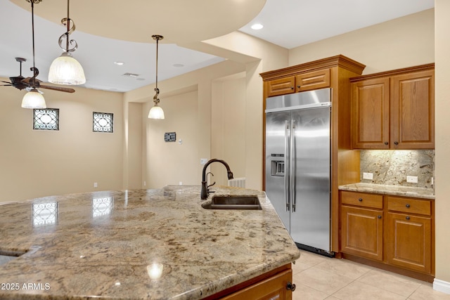 1620 E Sattoo Way, Queen Creek, AZ 85140 - kitchen featuring stainless steel built in fridge, a sink, ceiling fan, brown cabinets, and light stone counters