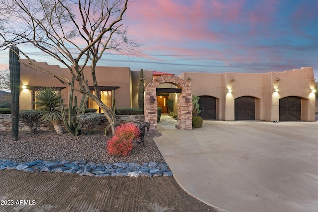 pueblo-style home featuring a garage