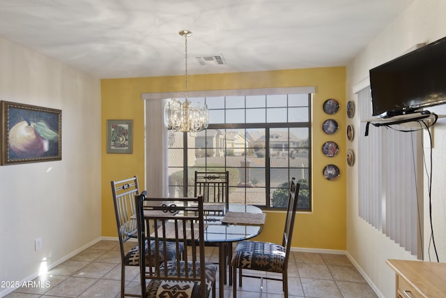 dining room with light tile patterned floors and a notable chandelier