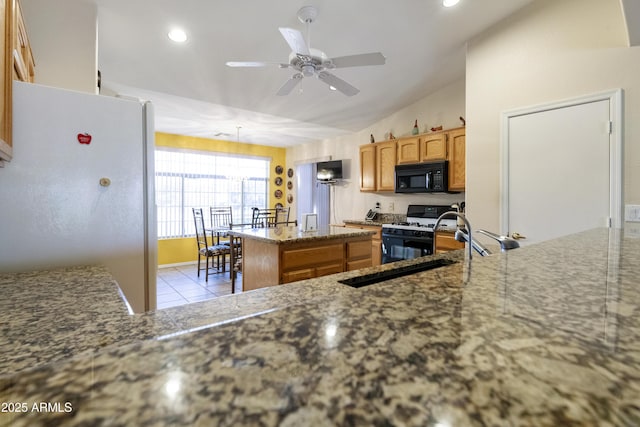 kitchen with lofted ceiling, ceiling fan, a center island, gas range, and white fridge