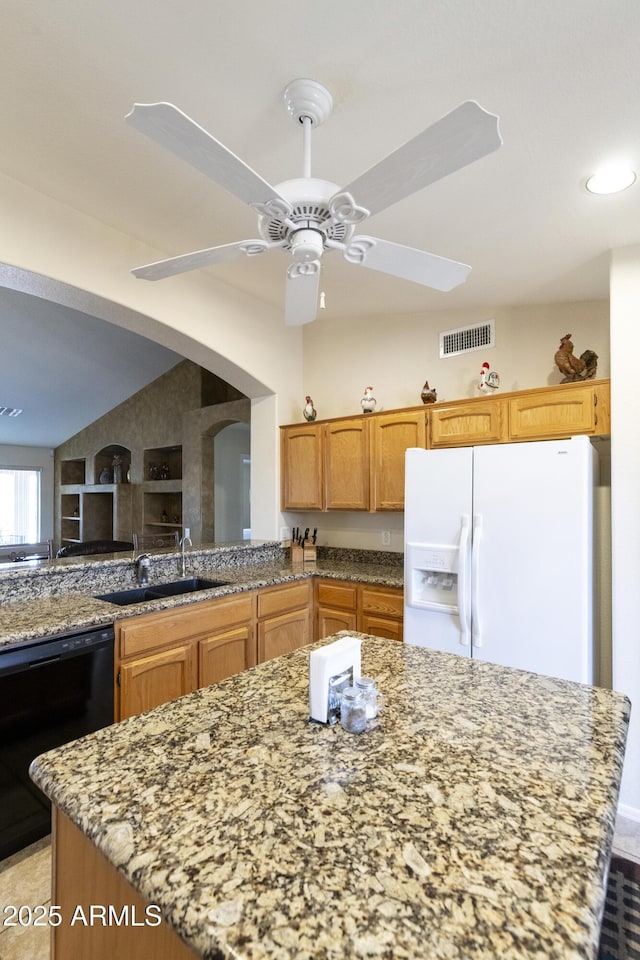 kitchen with built in shelves, sink, light stone counters, black dishwasher, and white refrigerator with ice dispenser