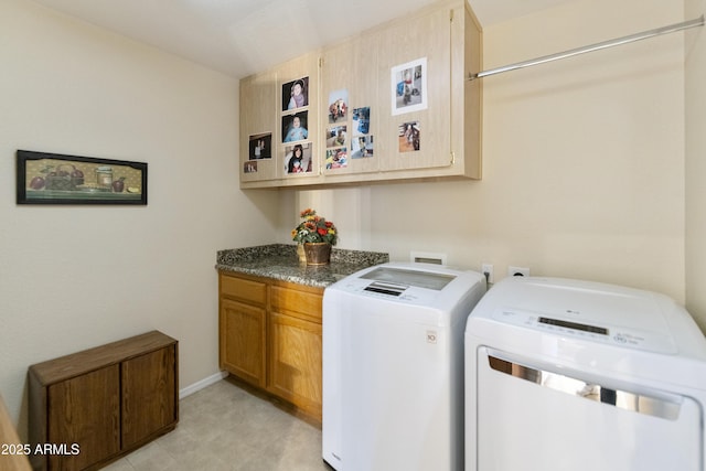 clothes washing area with cabinets and washing machine and clothes dryer