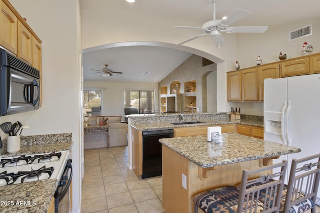 kitchen featuring lofted ceiling, sink, a breakfast bar area, a kitchen island, and black appliances