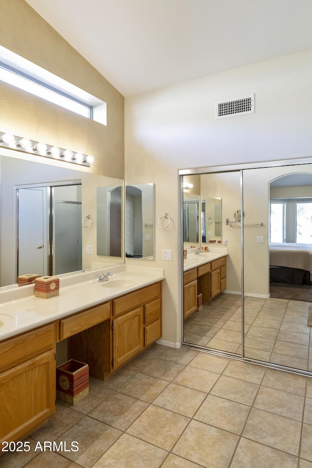 bathroom featuring lofted ceiling, tile patterned flooring, and vanity