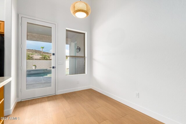 unfurnished living room featuring vaulted ceiling, ceiling fan with notable chandelier, and light hardwood / wood-style floors