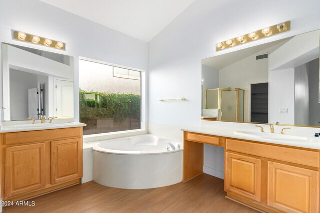 bathroom with tiled shower, vanity, toilet, and hardwood / wood-style flooring