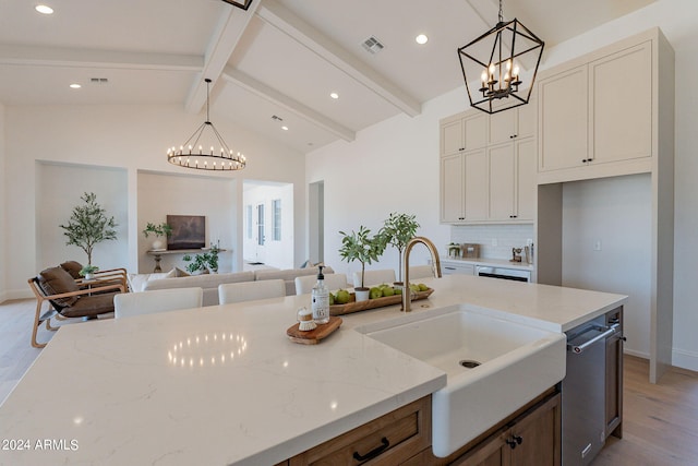 kitchen featuring light hardwood / wood-style flooring, hanging light fixtures, sink, and lofted ceiling with beams