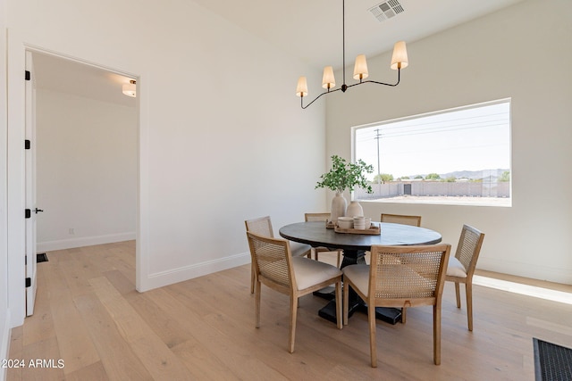 dining room with light hardwood / wood-style flooring and a chandelier