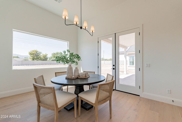 dining area with light hardwood / wood-style flooring and a chandelier