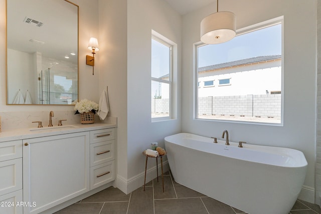 bathroom with tile patterned flooring, vanity, and separate shower and tub