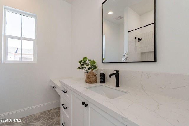 bathroom with tile patterned floors, vanity, plenty of natural light, and tiled shower