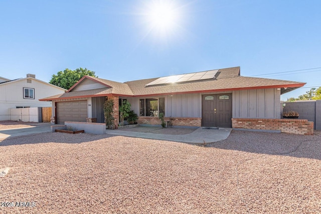 1316 N Spring Cir, Mesa, AZ 85203 - ranch-style home with board and batten siding, an attached garage, roof mounted solar panels, brick siding, and roof with shingles