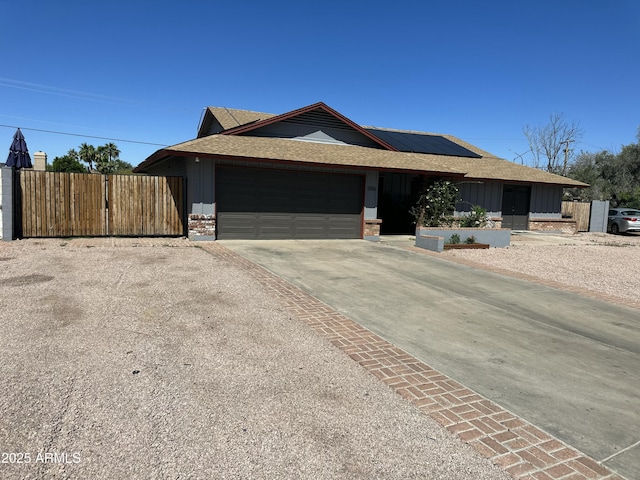 1316 N Spring Cir, Mesa, AZ 85203 - view of front of property featuring concrete driveway, a garage, a shingled roof, board and batten siding, and roof mounted solar panels
