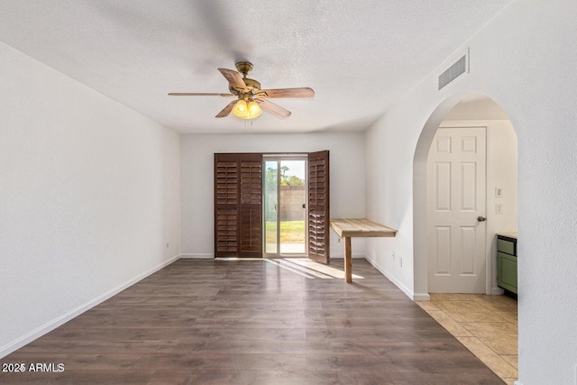 1316 N Spring Cir, Mesa, AZ 85203 - spare room featuring arched walkways, a textured ceiling, visible vents, a ceiling fan, and wood finished floors