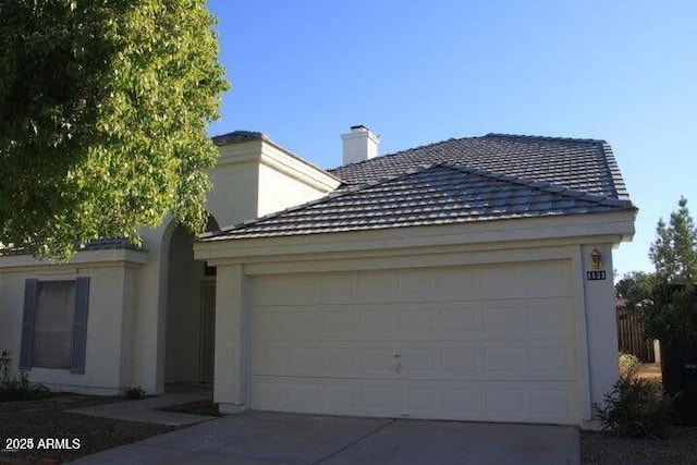 ranch-style home with driveway, an attached garage, and stucco siding