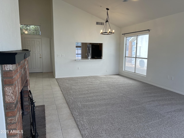 unfurnished living room featuring light tile patterned floors, high vaulted ceiling, a fireplace, visible vents, and an inviting chandelier