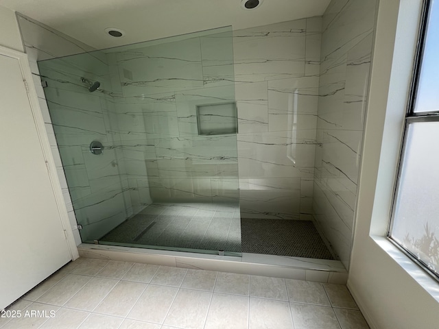 full bath featuring tile patterned flooring and a marble finish shower