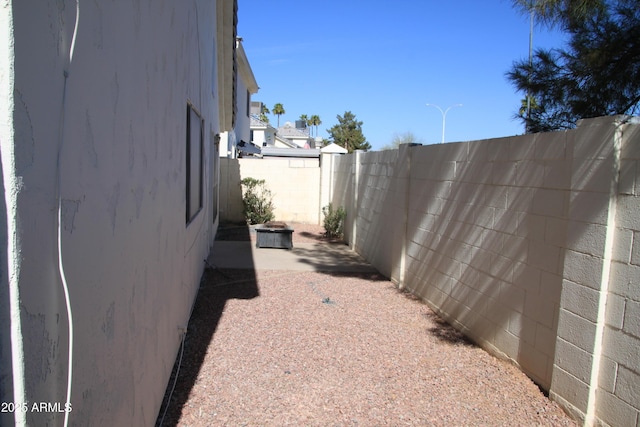 view of side of home featuring a patio area and a fenced backyard