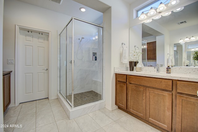 bathroom featuring tile patterned flooring, vanity, and a shower with shower door