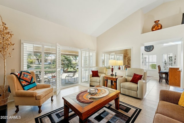 living area with light tile patterned floors and high vaulted ceiling