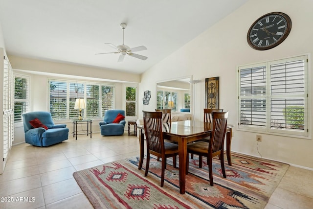 tiled dining area featuring a ceiling fan, a healthy amount of sunlight, baseboards, and high vaulted ceiling