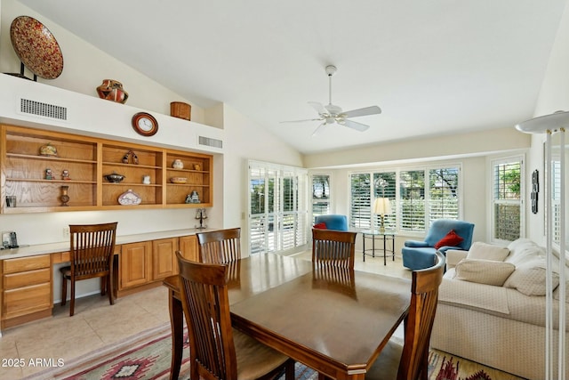 dining room with a ceiling fan, visible vents, light tile patterned flooring, vaulted ceiling, and built in desk