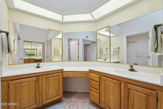 full bathroom featuring double vanity, a skylight, tile patterned floors, and a sink