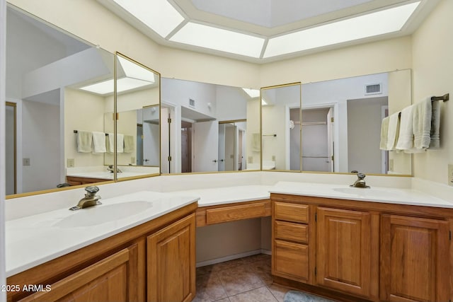 bathroom featuring tile patterned flooring, visible vents, a skylight, and vanity