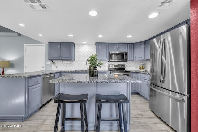 4116 E Downing St, Mesa, AZ 85205 - kitchen with stainless steel appliances, a center island, light wood-type flooring, gray cabinetry, and recessed lighting