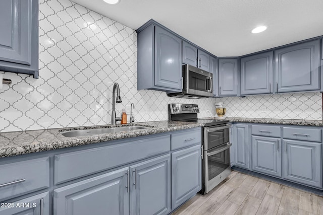4116 E Downing St, Mesa, AZ 85205 - kitchen featuring appliances with stainless steel finishes, dark stone countertops, backsplash, blue cabinetry, and recessed lighting