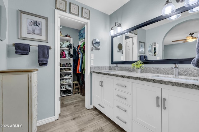 4116 E Downing St, Mesa, AZ 85205 - bathroom featuring double vanity, wood finished floors, ceiling fan, and a walk in closet