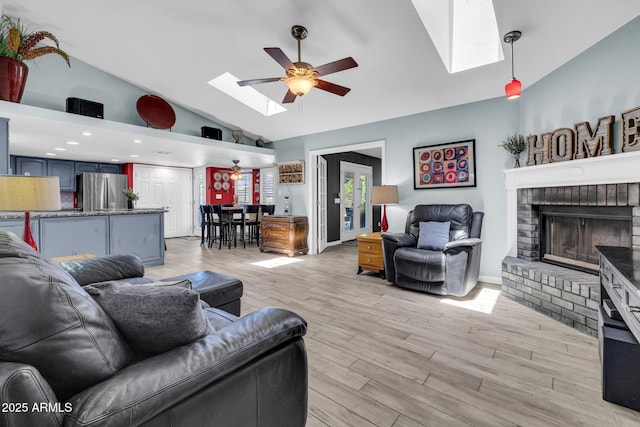 4116 E Downing St, Mesa, AZ 85205 - living room featuring a skylight, a ceiling fan, high vaulted ceiling, a brick fireplace, and light wood-style floors